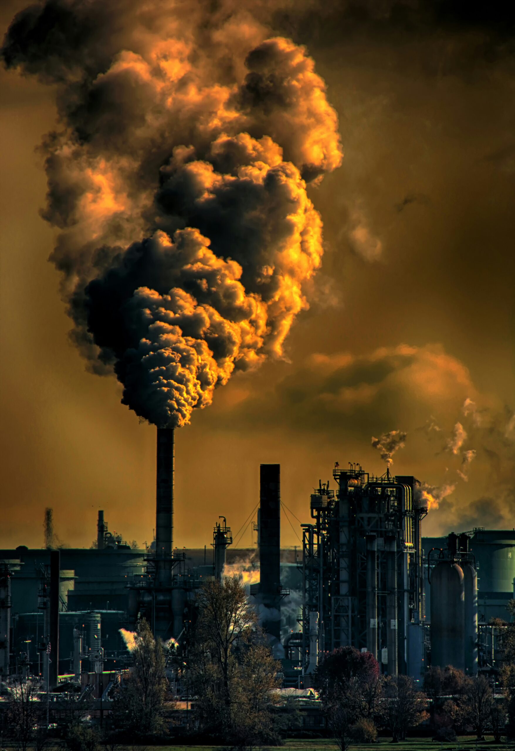Chris leboutillier c7rwvgl8lpa unsplash | trim tab Image of factory pipes with billowing smoke against an orange sky