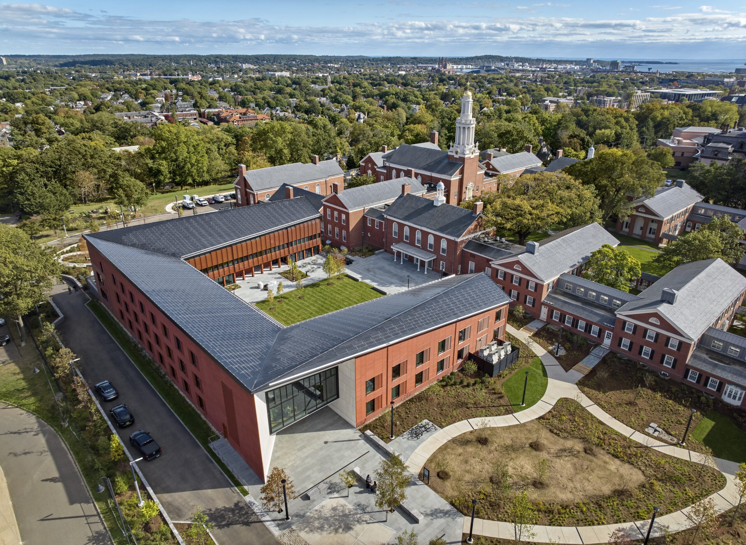 Brunercottyaledivinityschool03robertbensonphotography | trim tab Aerial view of a university campus red brick buildings a tall white clock tower green lawns and surrounding trees and streets