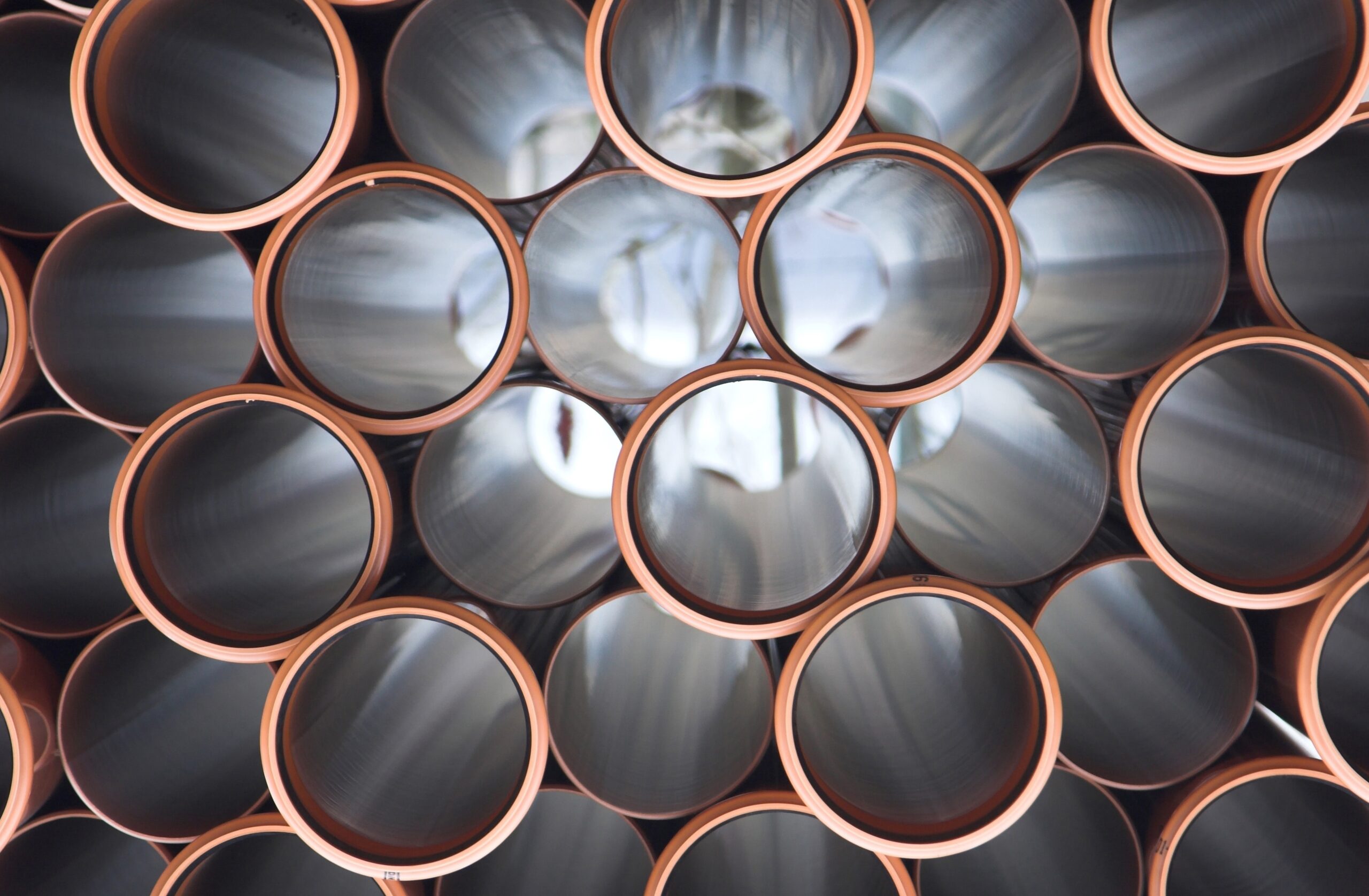 Shutterstock166416770 | trim tab Stack of orange rimmed metal pipes viewed from the front forming a honeycomb like grid